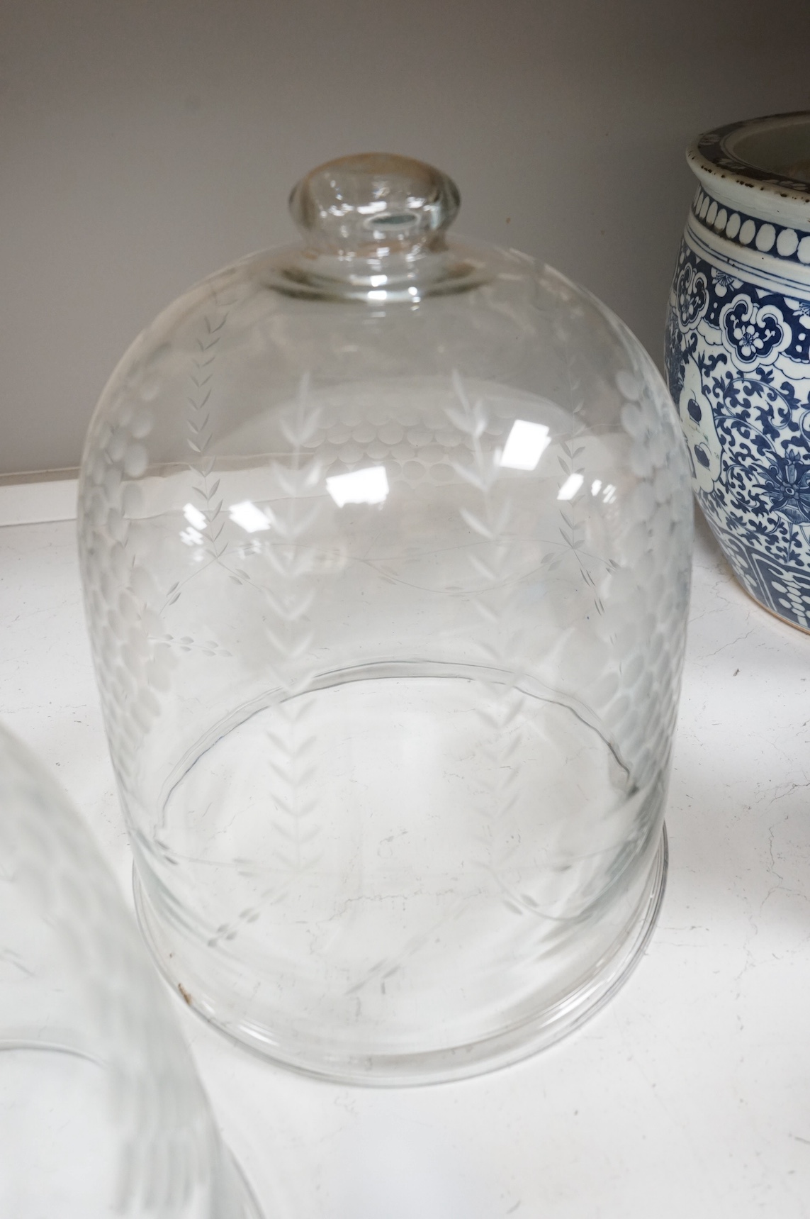 A pair of continental glass engraved cheese domes, 37cm high. Condition - good